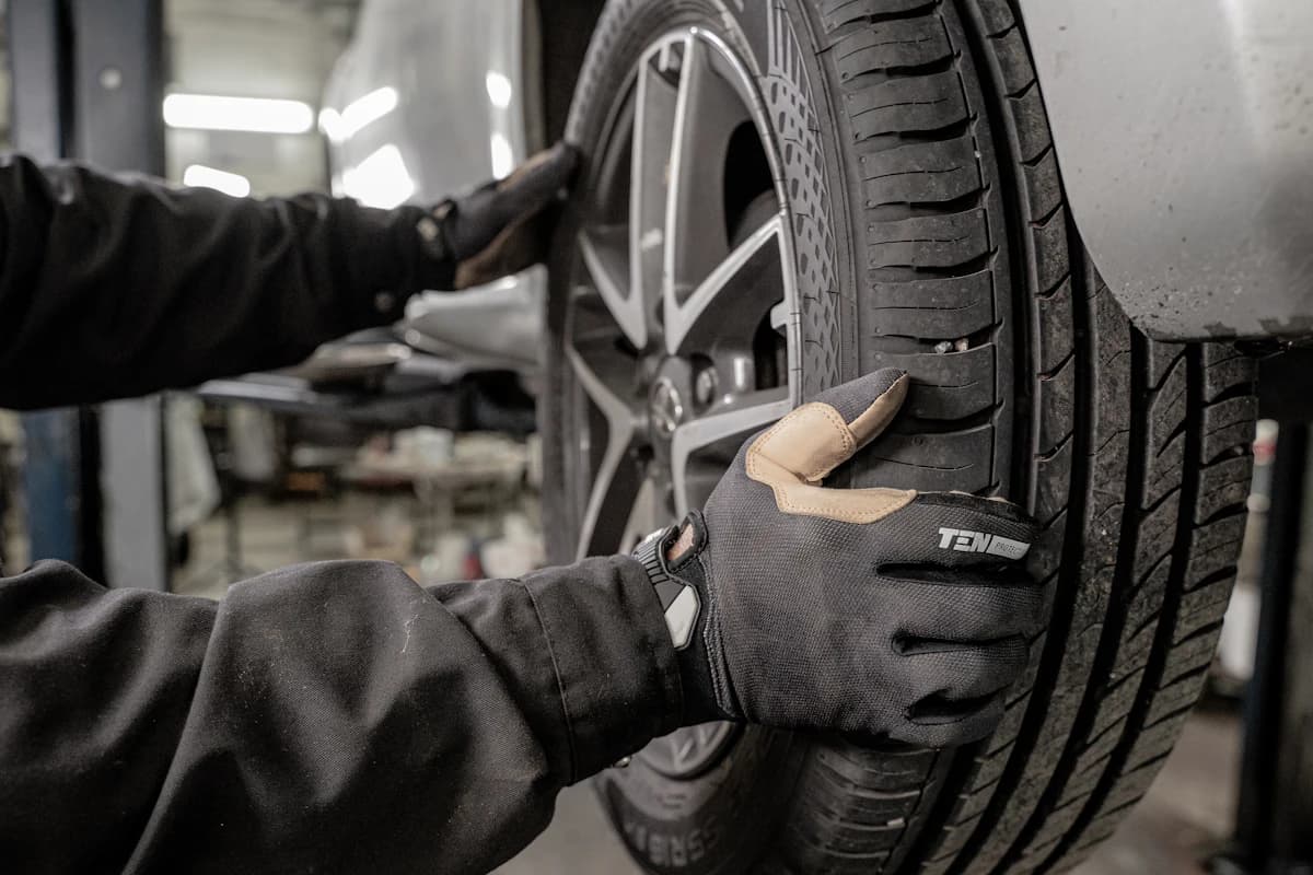 Tyre technician checking a car tyre